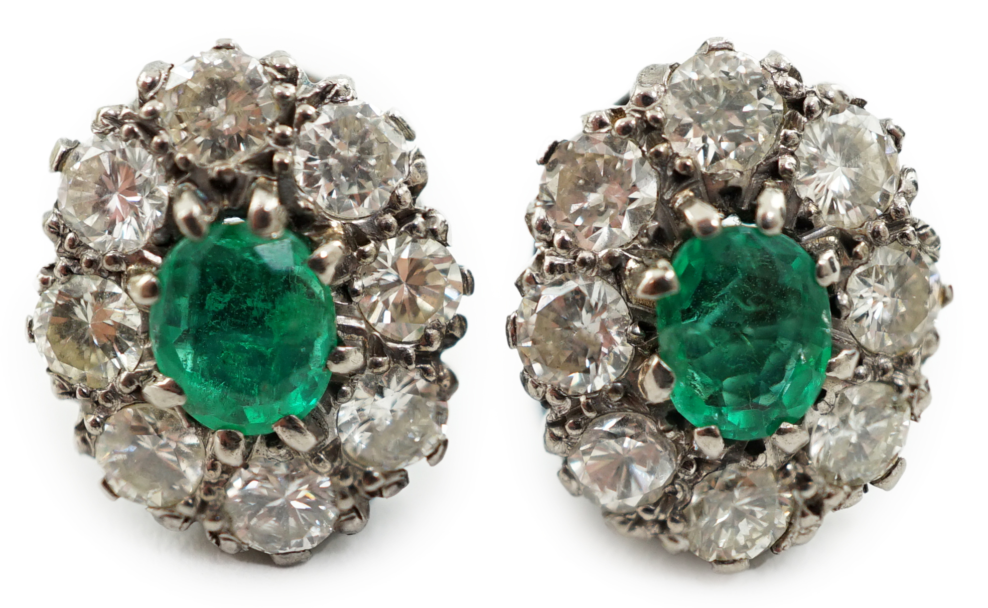 A pair of white gold, single stone emerald and eight stone diamond set oval cluster earrings